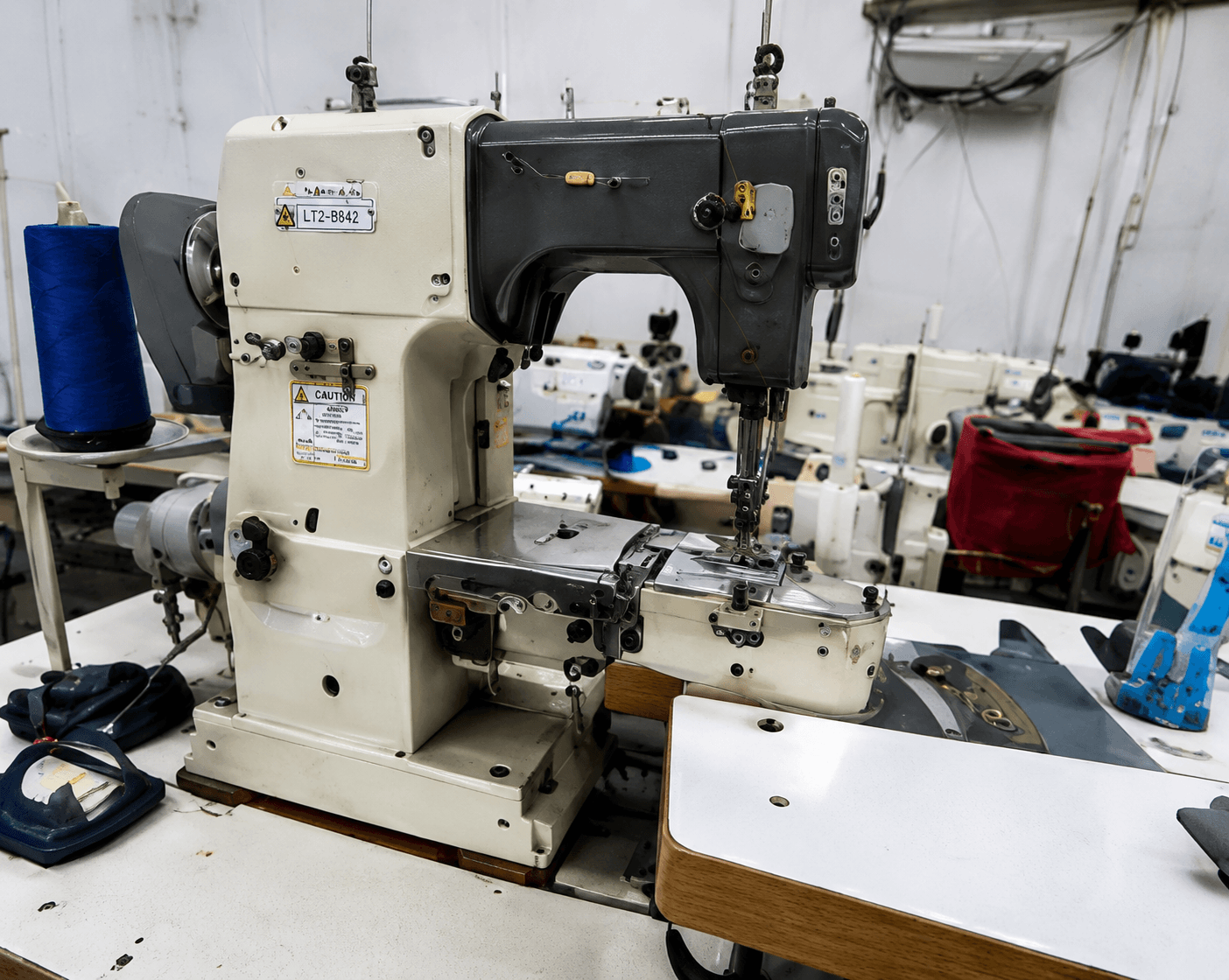 Button attaching machine used in professional workwear manufacturing